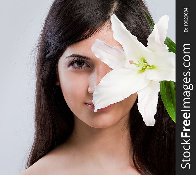 Beautiful young woman with fresh clean skin and white flower. Beautiful young woman with fresh clean skin and white flower
