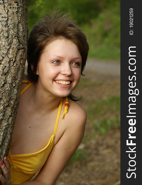 Portrait of a young woman peeking from behind a tree. Portrait of a young woman peeking from behind a tree