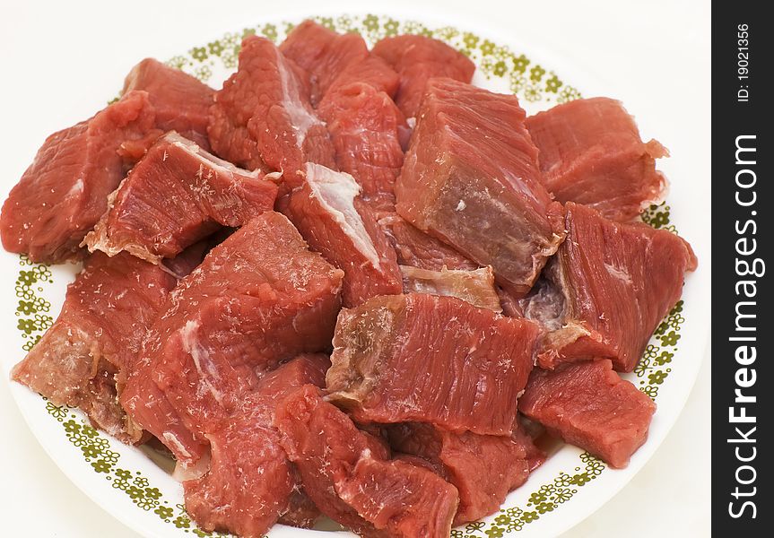 Chilled beef slices on a plate isolated on white background