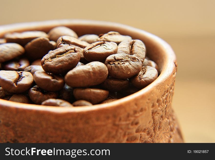 The coffee fried brown grains in an ancient clay pot. The coffee fried brown grains in an ancient clay pot