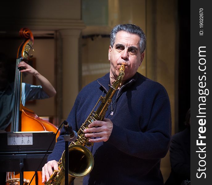 An older man playing the saxophone. An older man playing the saxophone