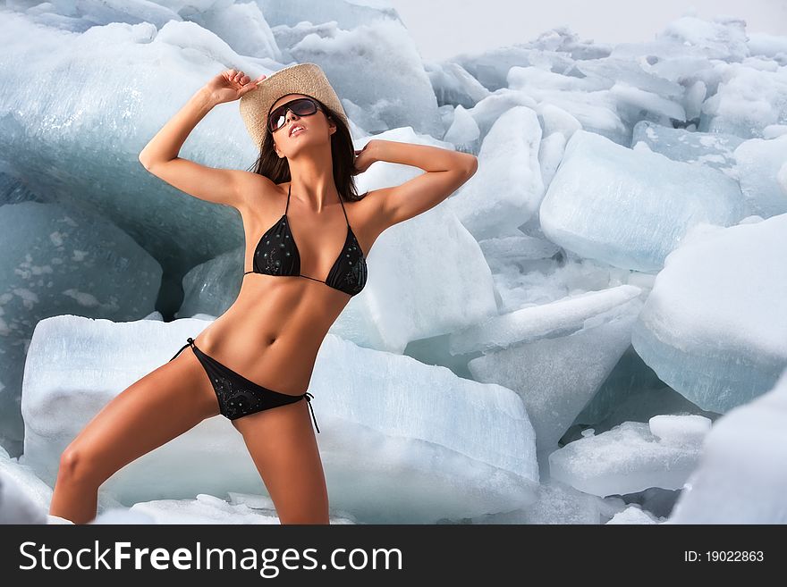 A studio portrait of a nude woman in bikini posing against the background of ice blocks. A studio portrait of a nude woman in bikini posing against the background of ice blocks.