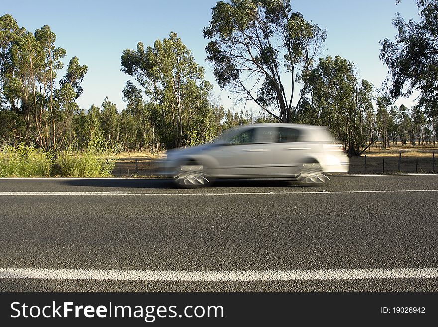 Rural road with moving automobile, excessive speed