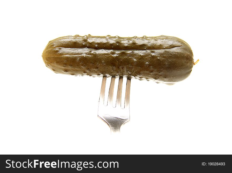 Tasty marinaded cucumber on plug on white background. Isolated.