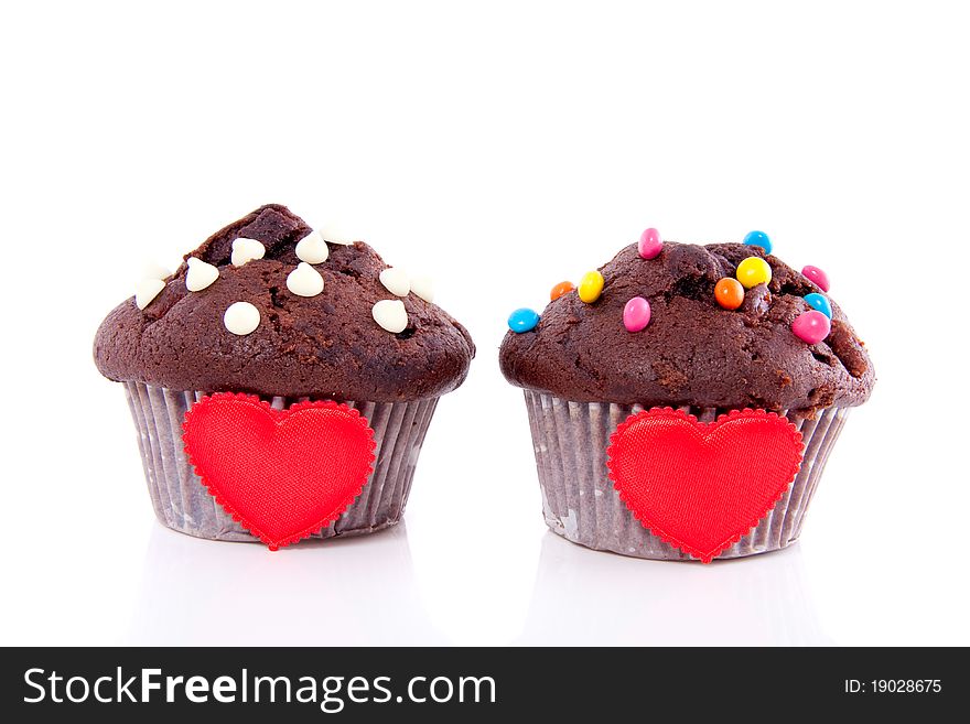 Two chocolate muffins with red hearts isolated over white. Two chocolate muffins with red hearts isolated over white