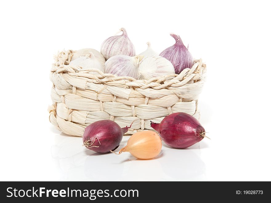 Garlic in a wicker basket with onions isolated over white. Garlic in a wicker basket with onions isolated over white