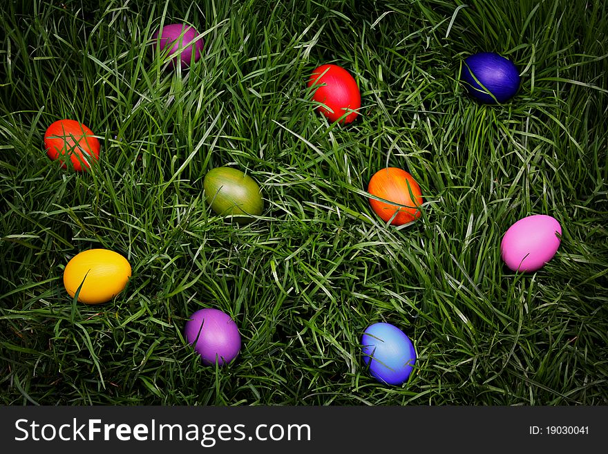 Colorful Easter eggs hidden in the grass - background