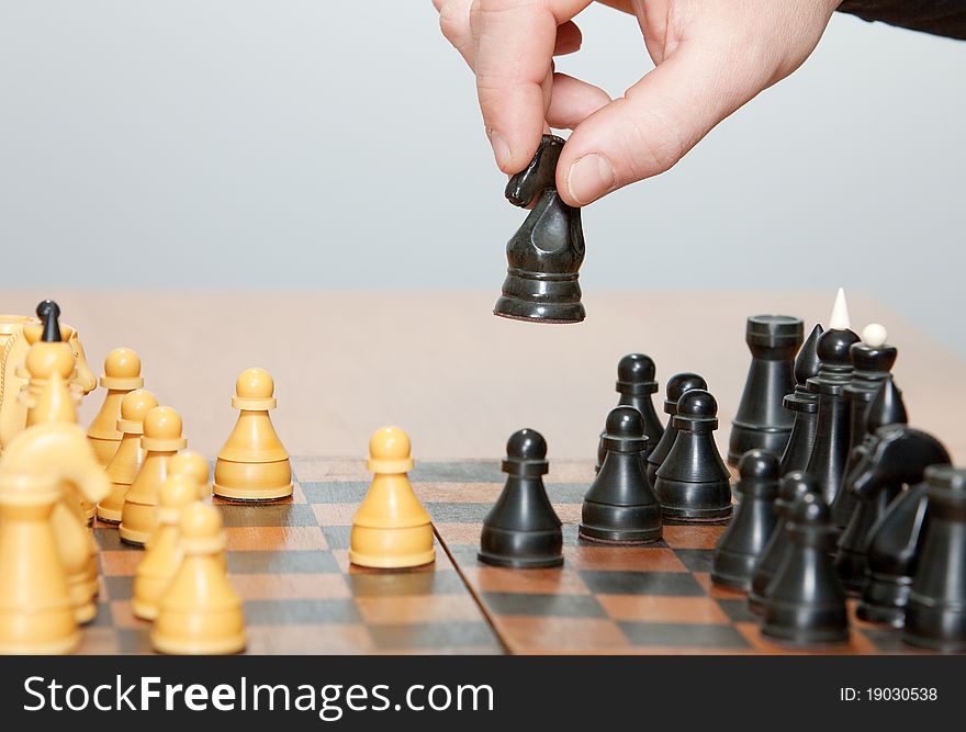 The hand moves a horse in chess game