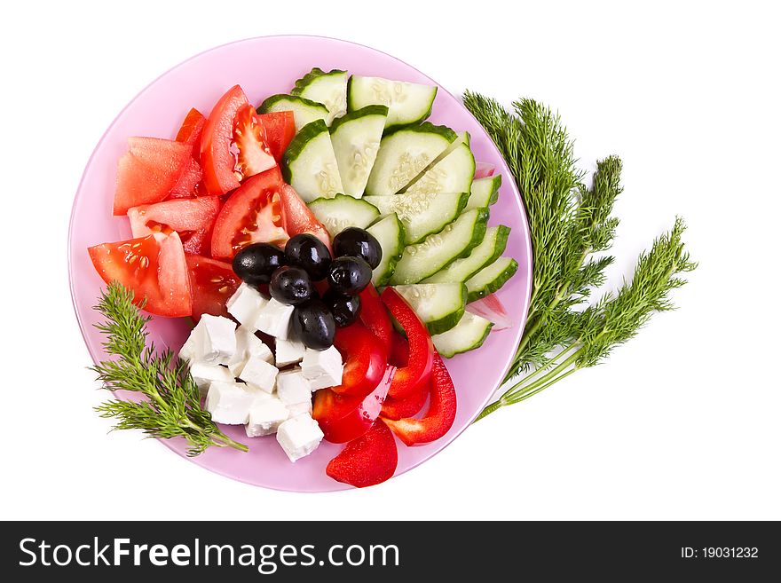 Plate of fresh cut vegetables and dill across white