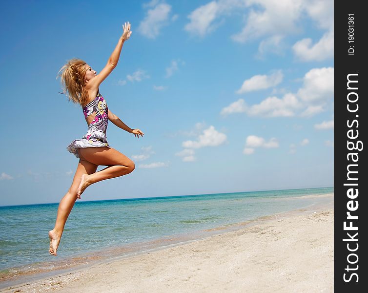 Young attractive woman jumping on beach