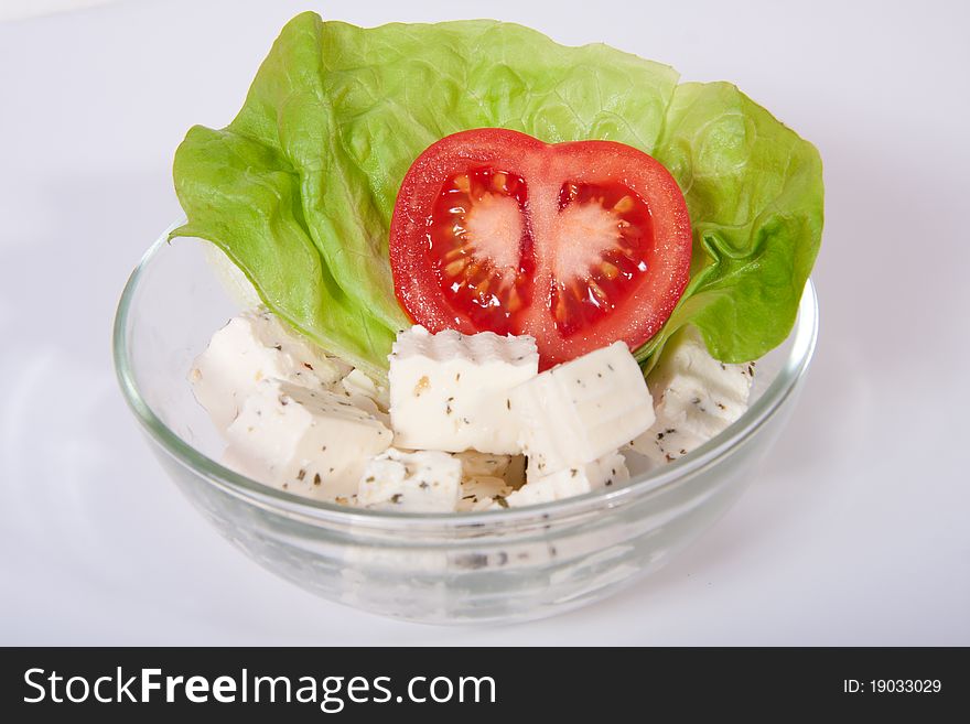 Fresh salad with tomato, feta cheese and a leaf of salad