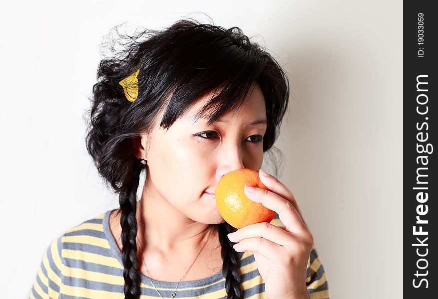 Young asian girl holding mandarin. Young asian girl holding mandarin.