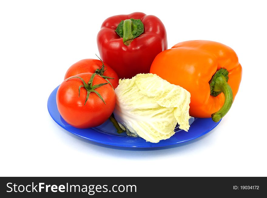Fresh vegetbles on blue plate, isolated on a white background