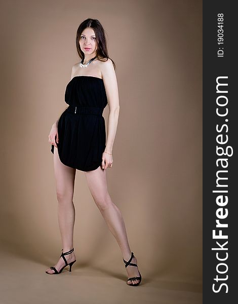 Beautiful woman in short black dress posing