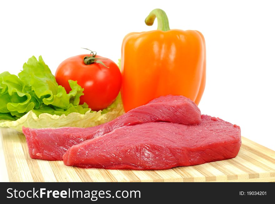 Vegetables and raw beef, focus on the meat. Vegetables and raw beef, focus on the meat