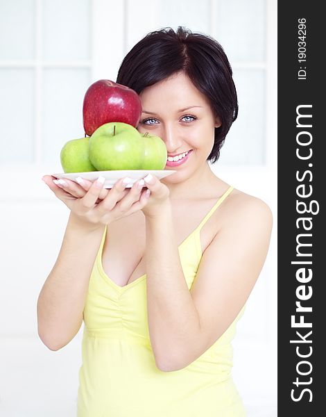 Girl holding apples on a light background