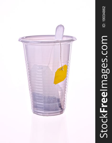 Tea in a plastic glass on a light grey background