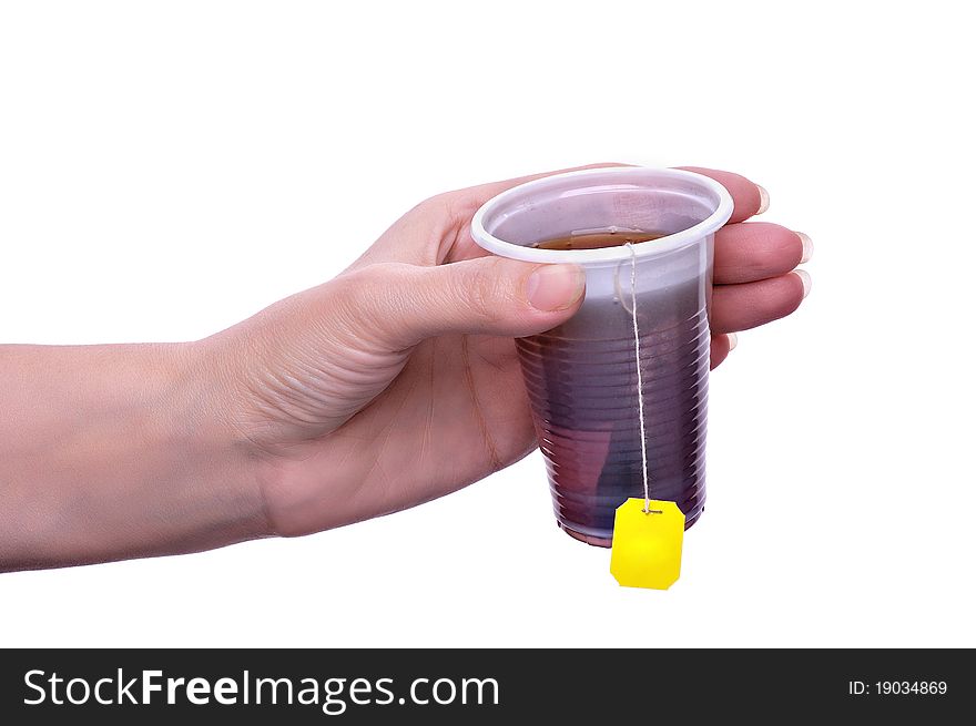 Tea in a plastic glass on a light grey background