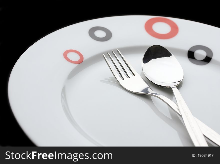 Plate, spoon and fork on dark background. Plate, spoon and fork on dark background