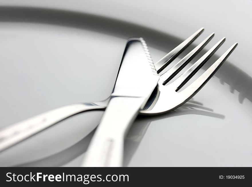 Table knife and fork over plate. Table knife and fork over plate