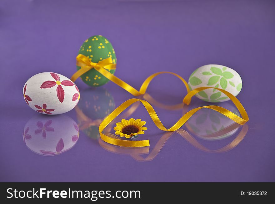 Three painted eggs photographed on violet background. Three painted eggs photographed on violet background