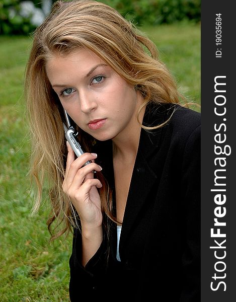 Businesswoman talking to a client on her cellphone outdoors.