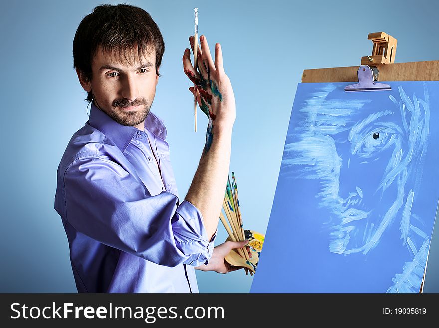 Portrait of an artist painting on easel. Shot in a studio. Portrait of an artist painting on easel. Shot in a studio.