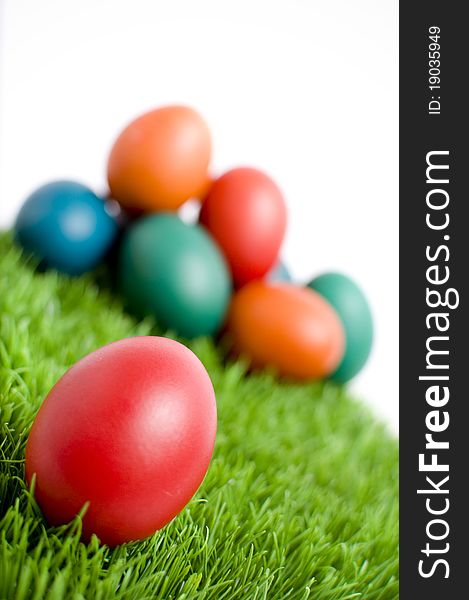 Colorful Easter eggs on green grass, with copy space