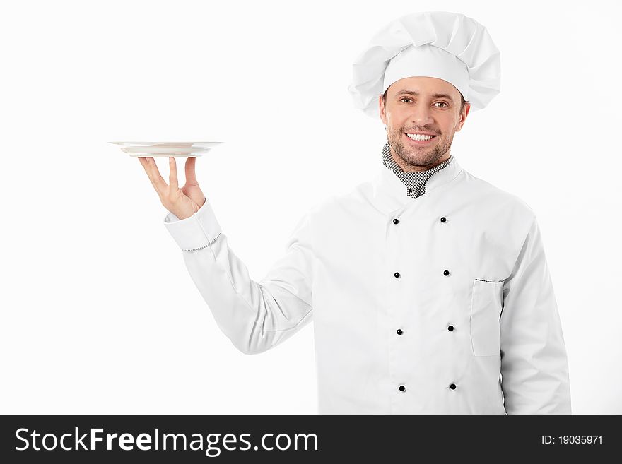 The young cook keeps an empty plate on a white background. The young cook keeps an empty plate on a white background