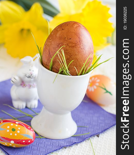 Easter Eggs in eggcup with flower on background