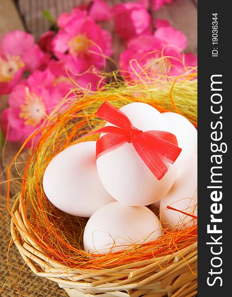 Easter still-life. Eggs in a basket and flowers