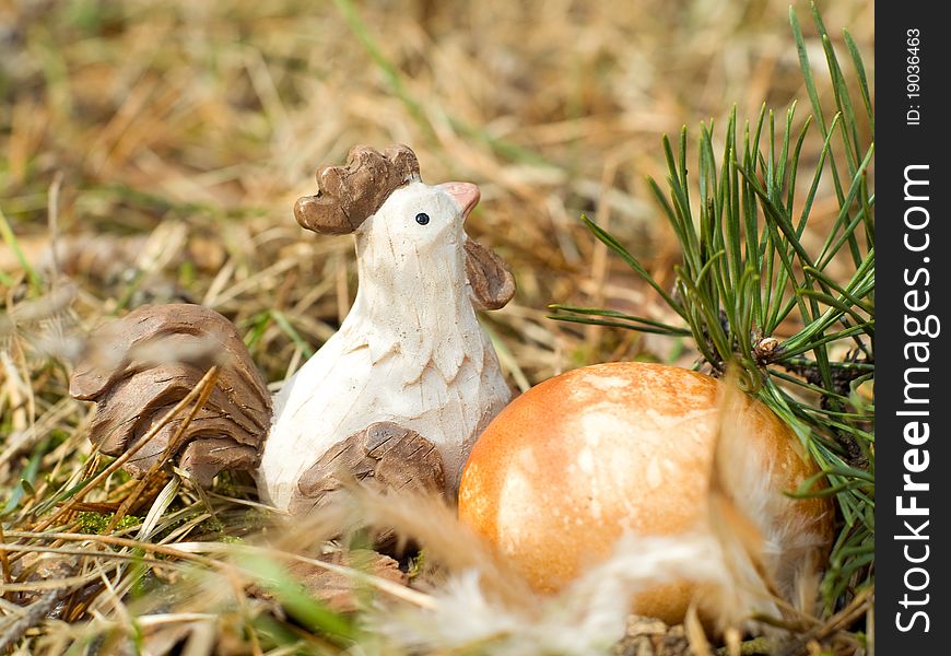 Easter Egg in  grass with chicken toy and feather