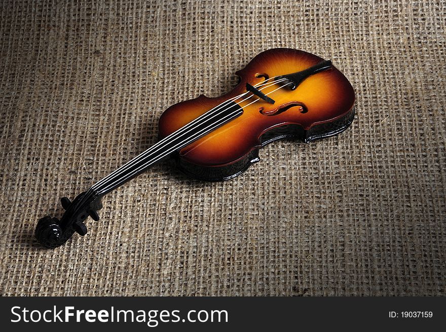 A low key image of a violin, photographed in a studio.