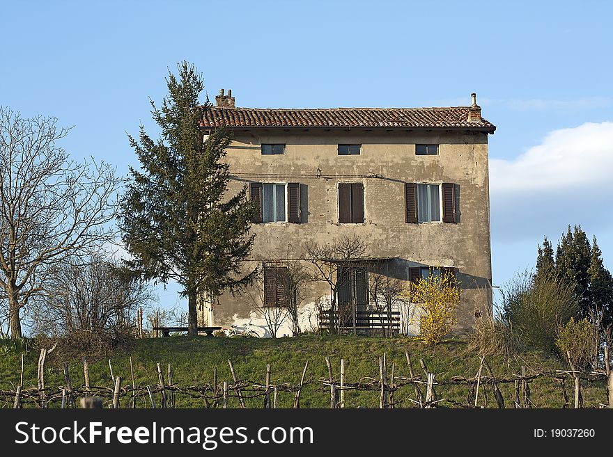 An old house on the top of a slope. The house is above the vineyard.