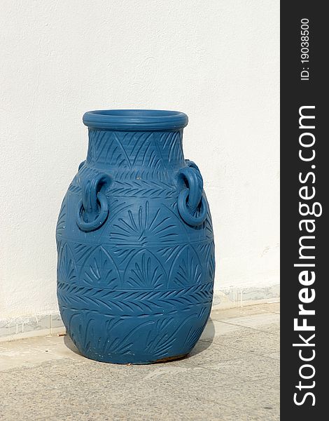 Big blue amphora on terrace against white wall. Big blue amphora on terrace against white wall