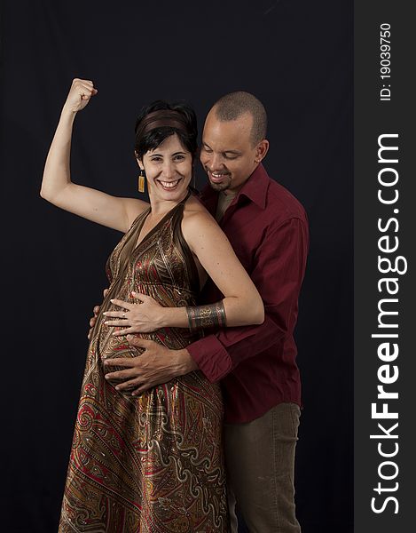 Portrait of young cheerful hispanic couple specting a child, isolated on black. Portrait of young cheerful hispanic couple specting a child, isolated on black