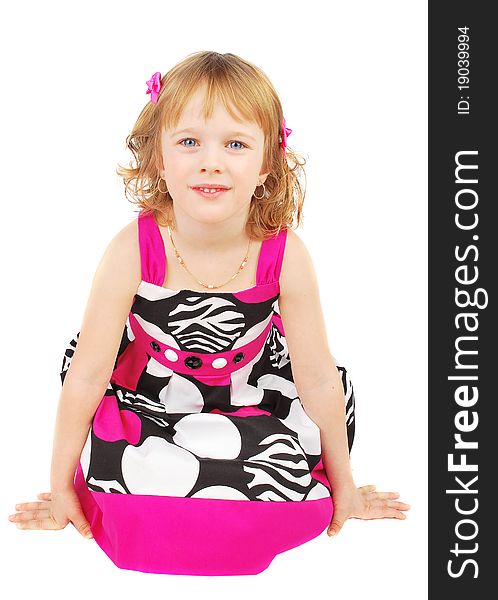 Pretty little girl wearing a pink and black summer dress smiling sitting on the floor isolated on white background. Pretty little girl wearing a pink and black summer dress smiling sitting on the floor isolated on white background.