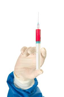 Hand Of A  Surgeon Holding A Syringe Stock Image