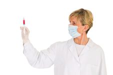 Female Doctor With Mask Holding A Syringe Stock Images