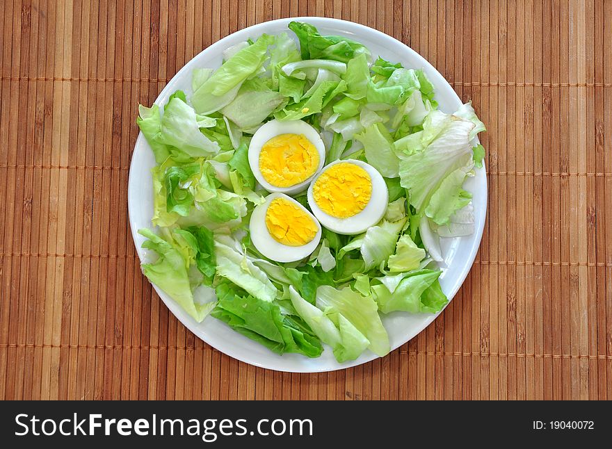 Boiled eggs slices over a bed of lettuce. Boiled eggs slices over a bed of lettuce