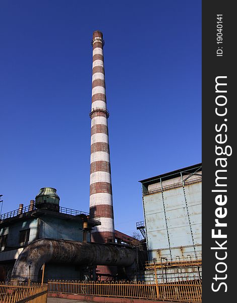 Disused Steel Plant Chimney With Blue Sky