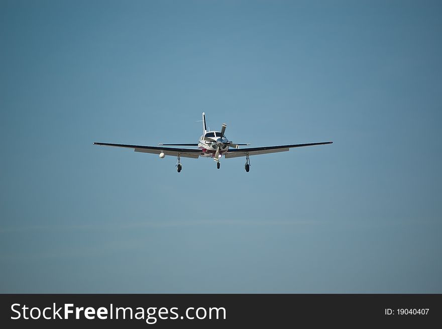 A small single-engined aircraft approaches the runway with its landing gear down. A small single-engined aircraft approaches the runway with its landing gear down.