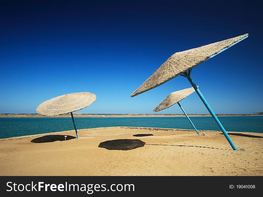 Wicker Beach Umbrella with wicker wind breaks.