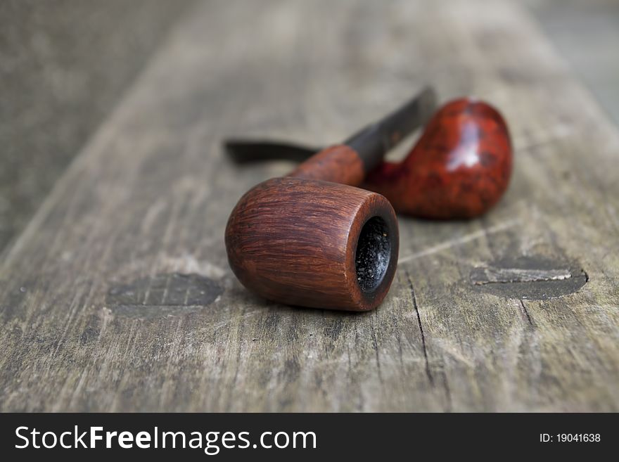 Two tobacco pipes on the wooden bench