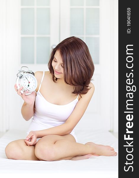 Girl with Alarm Clock on a light background