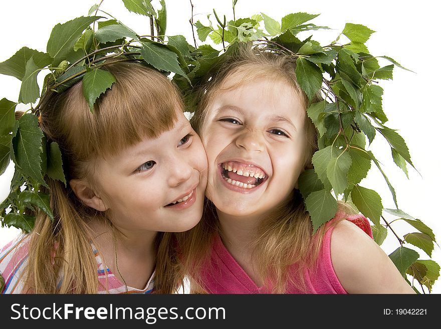 Cheerful little girl with a wreath on a head from birch leaves on a gray background. Cheerful little girl with a wreath on a head from birch leaves on a gray background