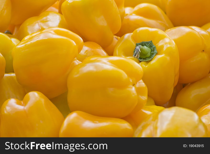 A pile of yellow peppers under natural light.