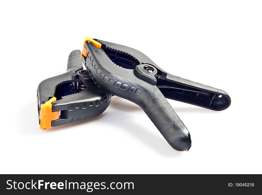 Two black plastic clamps on a white background. Two black plastic clamps on a white background