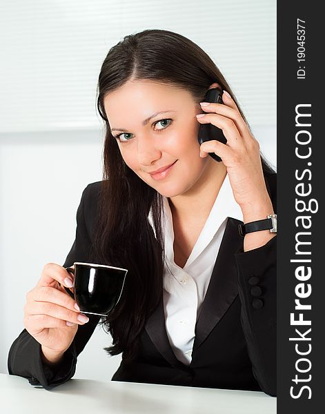 Girl in a business suit talking on the phone. Girl in a business suit talking on the phone