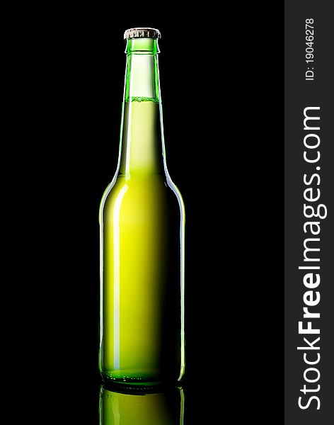 A green bottle of beer on a black background